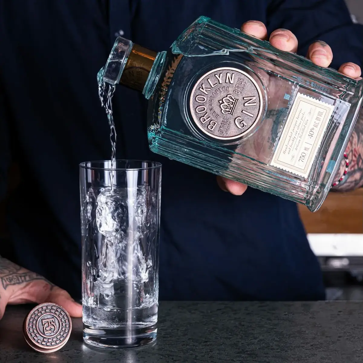 Brooklyn gin being poured over ice into a tall glass